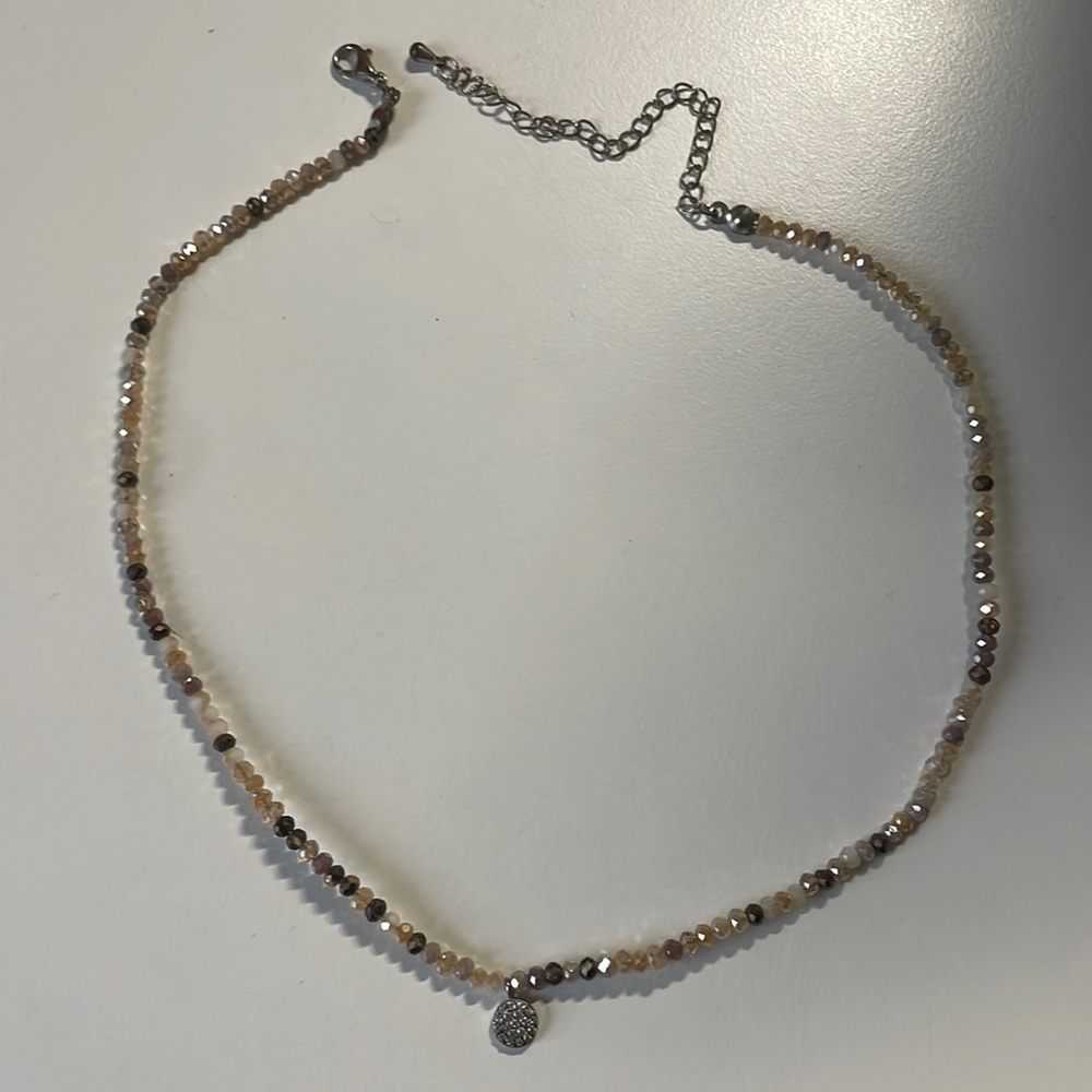 Varied hues of brown and tan jewels with a silver pendant necklace.